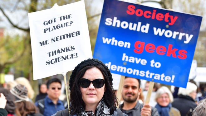 People carry signs as they participate in the March for Sciences in Amsterdam.