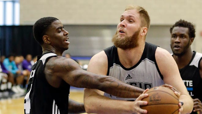Orlando Magic center Przemek Karnowski, right, attempts to shoot as he is guarded by Charlotte Hornets' Dwayne Bacon, left, during the first half of an NBA Summer League game in Orlando.