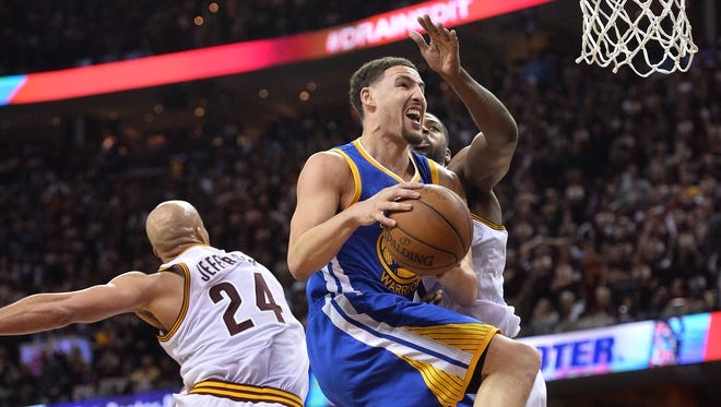 Golden State Warriors guard Klay Thompson (11) shoots the ball past Cleveland Cavaliers forward Richard Jefferson (24) and center Tristan Thompson (13) during the second quarter in Game 3 of the NBA Finals at Quicken Loans Arena.