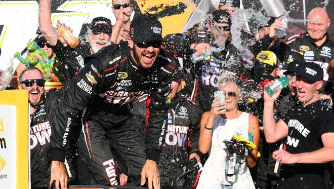 Round 1: Martin Truex Jr., center, celebrates with his crew and girlfriend Sherry Pollex, holding a phone, after winning the opening race of the Chase at Chicagoland Speedway and securing a berth in the second round.