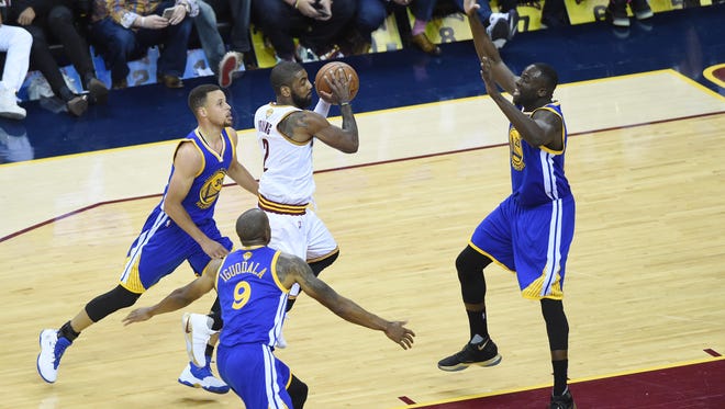 Cleveland Cavaliers guard Kyrie Irving (2) controls the ball between Golden State Warriors guard Stephen Curry (30), forward Andre Iguodala (9), and forward Draymond Green (23) during the first quarter in Game 3 of the NBA Finals at Quicken Loans Arena. Mandatory Credit: Ken Blaze-USA TODAY Sports