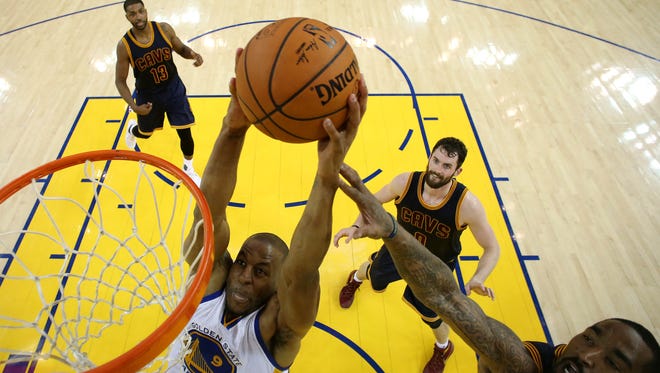 Golden State Warriors forward Andre Iguodala (9) dunks the ball against Cleveland Cavaliers guard J.R. Smith (5) during the first quarter in game one of the NBA Finals at Oracle Arena.