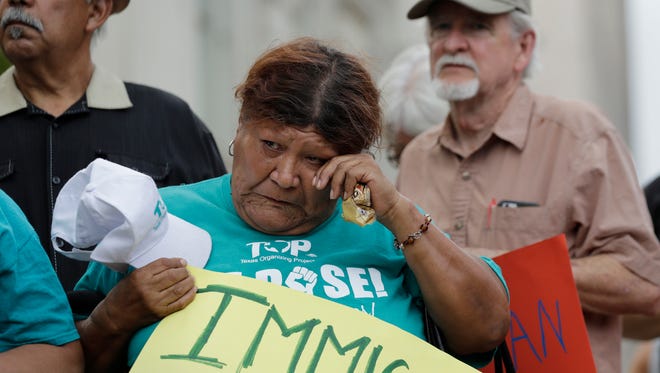 Eldia Contreras wipes away a tear as she takes part in a vigil at San Fernando Cathedral for victims who died as a result of being transported in a tractor-trailer, July 23, 2017, in San Antonio.
