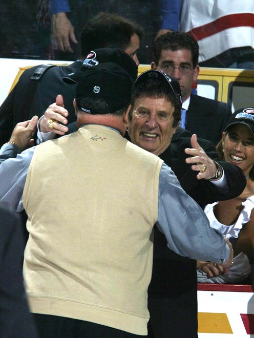 In 2002, Wings coach Scotty Bowman hugs Mike Ilitch at end of game when they won the Stanley Cup.