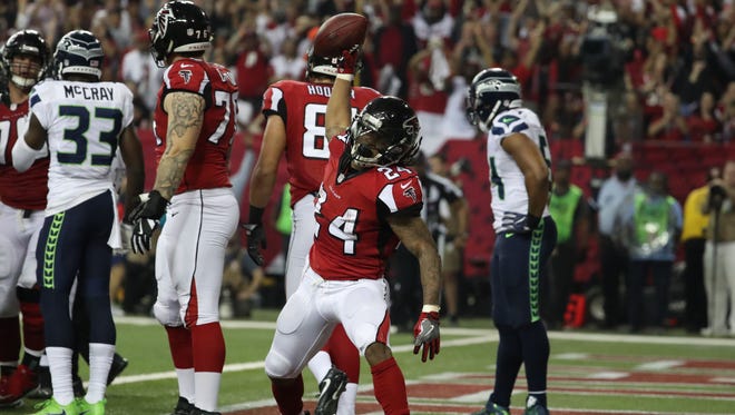 Atlanta Falcons running back Devonta Freeman (24) celebrates after scoring a touchdown against the Seattle Seahawks during the third quarter in the NFC Divisional playoff at Georgia Dome.