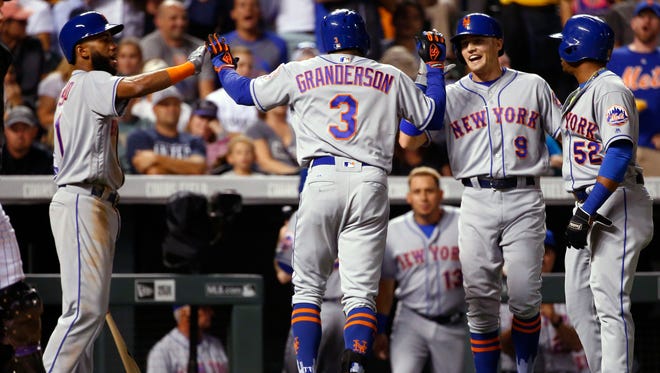 Mets' Curtis Granderson (3) is congratulated by teammates Amed Rosario, left, Brandon Nimmo (9) and Yoenis Cespedes after hitting a three-run home run off Colorado Rockies starting pitcher Tyler Chatwood during the sixth inning of a game Wednesday, Aug. 2, 2017, in Denver.