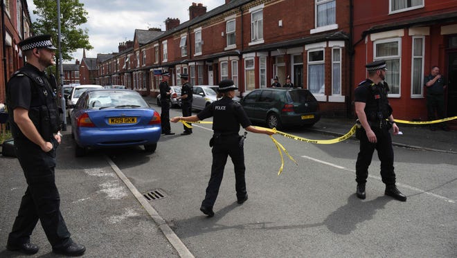 Police officers set a cordon outside the entrance of a property in the Moss Side area of Manchester on May 27, 2017 during an operation.