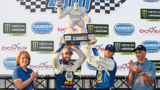 Chase Elliott, left, and crew chief Alan Gustafson  raise the Monster trophy after winning the 2018 playoff race at Dover International Speedway.