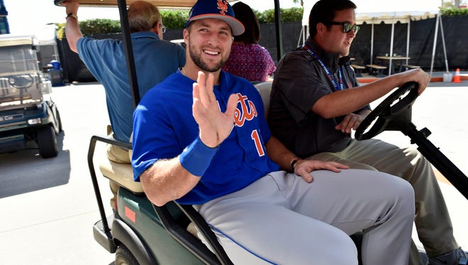 Tim Tebow is seen leaving on a golf cart after addressing members of the media.