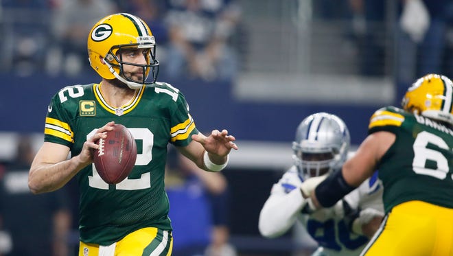 Green Bay Packers quarterback Aaron Rodgers (12) drops back to pass during the first quarter against the Dallas Cowboys in the NFC Divisional playoff game at AT&T Stadium.