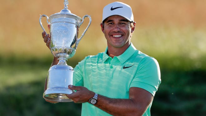 Brooks Koepka poses with the winning trophy after the U.S. Open golf tournament Sunday, June 18, 2017, at Erin Hills in Erin, Wis. (AP Photo/Chris Carlson)