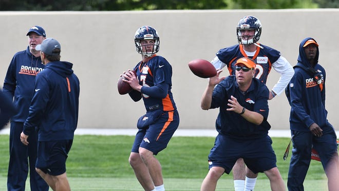 Denver Broncos quarterback Trevor Siemian (13) and quarterback Paxton Lynch (12) during organized training activities at the UCHealth Training Center.