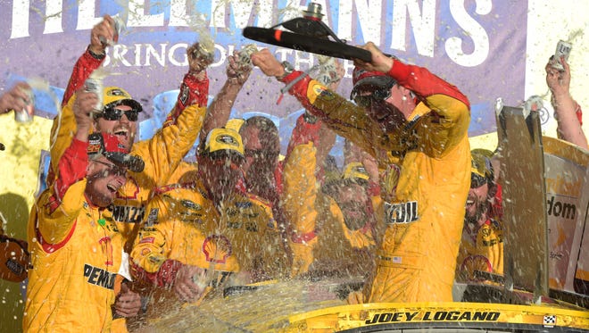 Round 2: Joey Logano climbs from the roof of his No. 22 Ford to celebrate his win in the elimination race at Talladega Superspeedway on Oct. 23.