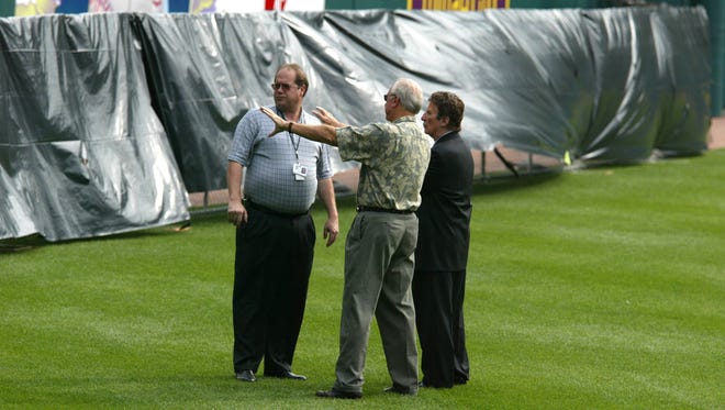 Mike Ilitch listens to Al Kaline, as he   points and talks about  the  temporary fence placed in left field at Comerica Park in 2002. On the left is Tigers VP of Park Operations John Pettit.