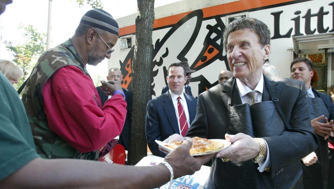 Mike Ilitch, founder of Little Caesars pizza, serves pizza slices to the homeless in Washington in 2007. He also owns the Detroit Red Wings and Tigers.