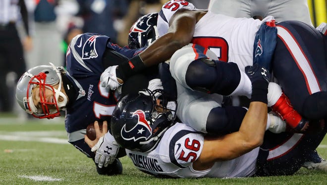 New England Patriots quarterback Tom Brady (12) is sacked by Houston Texans inside linebacker Brian Cushing (56) and outside linebacker Whitney Mercilus (59) during the first half in the AFC Divisional playoff game at Gillette Stadium.
