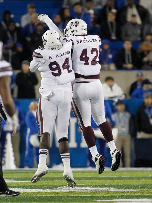 Mississippi State Bulldogs defensive lineman Nelson Adams (94) and lineman Marquiss Spencer (42) celebrate during the game against the Kentucky Wildcats in the first half at Commonwealth Stadium.