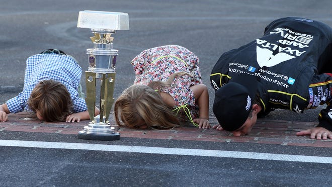 Gordon kisses the bricks with his son Leo Benjamin Gordon and daughter Ella Sofia Gordon after winning the Crown Royal Brickyard 400 at Indianapolis Motor Speedway, July 27.