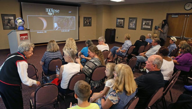 Inside the Milwaukee Public Museum, people watch a live video feed of the eclipse being broadcast from Madras, Ore., by NASA.