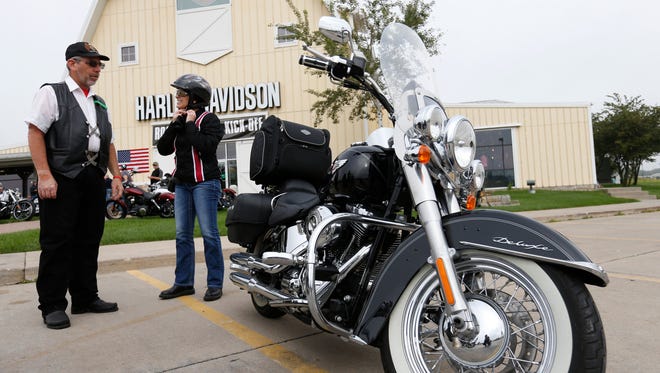 Sen. Joni Ernst takes off her helmet as she arrives Saturday, Aug. 27, 2016, at the starting point before leading riders to the Iowa State Fairgrounds for the second annual Roast and Ride fundraiser in Des Moines.
