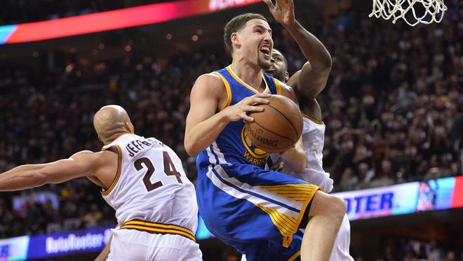 Golden State Warriors guard Klay Thompson (11) shoots the ball past Cleveland Cavaliers forward Richard Jefferson (24) and center Tristan Thompson (13) during the second quarter in game three of the NBA Finals at Quicken Loans Arena.