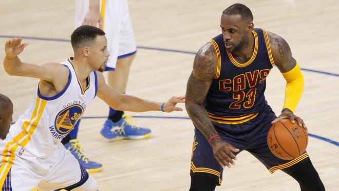 Cleveland Cavaliers forward LeBron James (23) controls the ball against Golden State Warriors guard Stephen Curry (30) during the first half in game one of the NBA Finals at Oracle Arena.