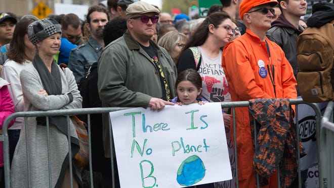 People with signs attend a rally before the march for Science in New York.