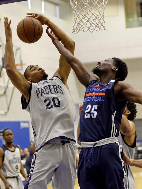 Indiana Pacers' Ben Moore (20) and Oklahoma City Thunder's Daniel Hamilton (25) battle for a rebound during the first half of an NBA Summer League game in Orlando.