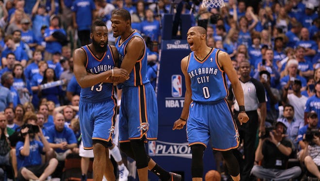 James Harden, Kevin Durant and Russell Westbrook of the Oklahoma City Thunder celebrate after scoring with 10 seconds against the Dallas Mavericks during Game 4 of the Western Conference first round in the 2012 NBA Playoffs.