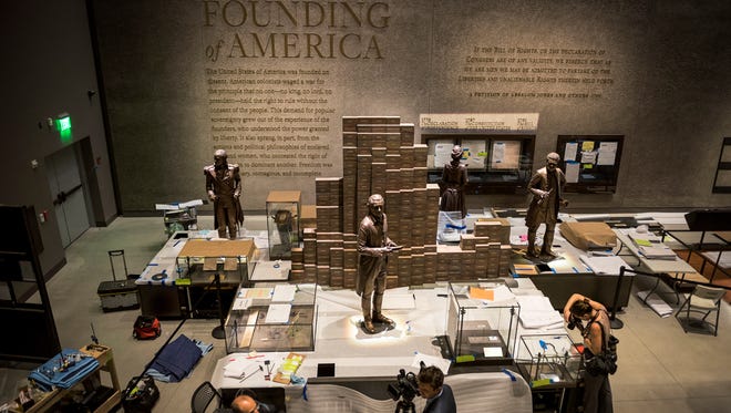 Members of the media view "The Founding of America" exhibit on the bottom floor during the media preview for the Smithsonian's National Museum of African American History and Culture in Washington, on Sept. 14, 2016