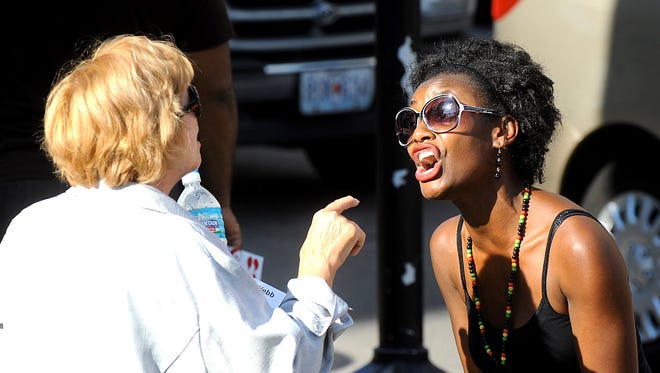 Lynn Acton, left, and Taj Sconyers exchange words during dual demonstrations, as police supporters and BLM protesters rally in the same location in Columbia, Mo., on Aug. 12, 2015.