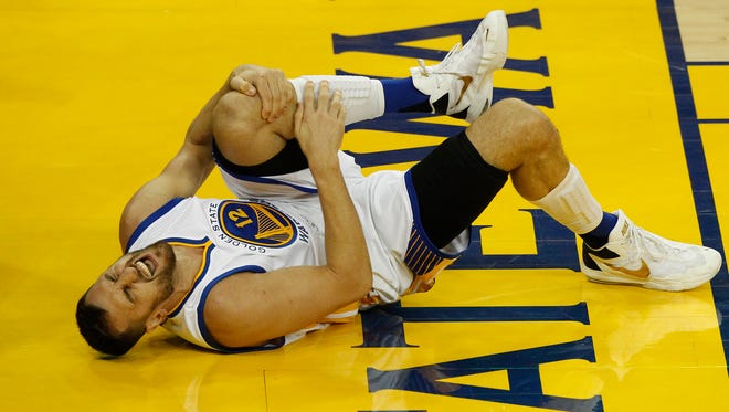 Golden State Warriors center Andrew Bogut (12) reacts after suffering an apparent injury against Cleveland Cavaliers during the second half in Game 5 of the NBA Finals at Oracle Arena.
