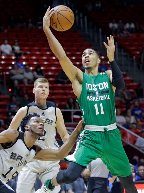 Boston Celtics forward Jayson Tatum lays the ball up as San Antonio Spurs forward Jaron Blossomgame (15) defends during the first half of an NBA Summer League game in Salt Lake City.