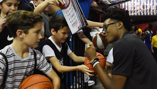 De'Aaron Fox #5 (R) of the Sacramento Kings signs autographs for fans before the team's game against the Milwaukee Bucks during the 2017 Summer League at the Thomas & Mack Center on July 12, 2017 in Las Vegas, Nevada.
