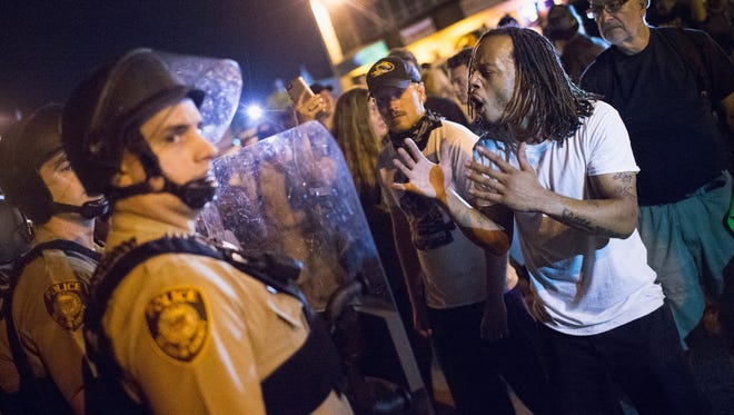Police and demonstrators clash during an Aug. 11, 2015 protest in Ferguson, Mo.