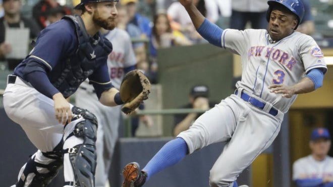 Mets' Curtis Granderson slides safely past Brewers catcher Jonathan Lucroy during the second inning Thursda in Milwaukee. Granderson scored from second on a hit by Yoenis Cespedes.