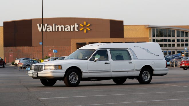 A hearse sits in the parking lot of a Walmart store where multiple people were found dead in San Antonio.