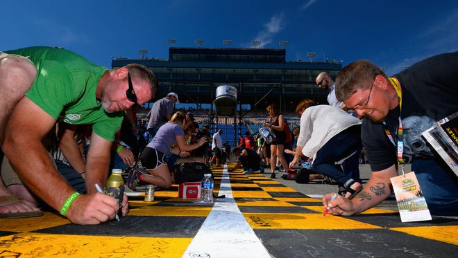 Round 1: Fans sign the start-finish line before the opening race of the Chase, Sept. 18 at Chicagoland Speedway.