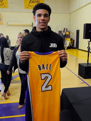 Newly drafted Los Angeles Lakers player Lonzo Ball poses for photographs with his game jersey following introduction to media at Toyota Sports Center.