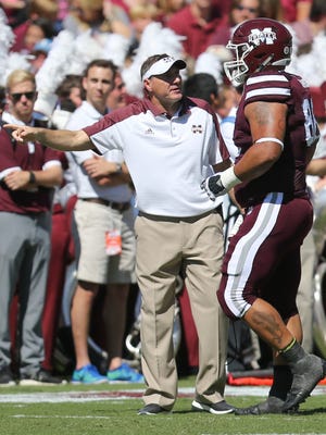 Mississippi State coach Dan Mullen talks to Nick James after he received a personal foul penalty against Auburn on Saturday.