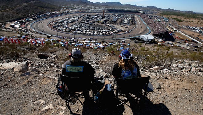 Round 3: Two fans take in the Can-Am 500 from a hill atop Phoenix International Raceway on Nov. 13.