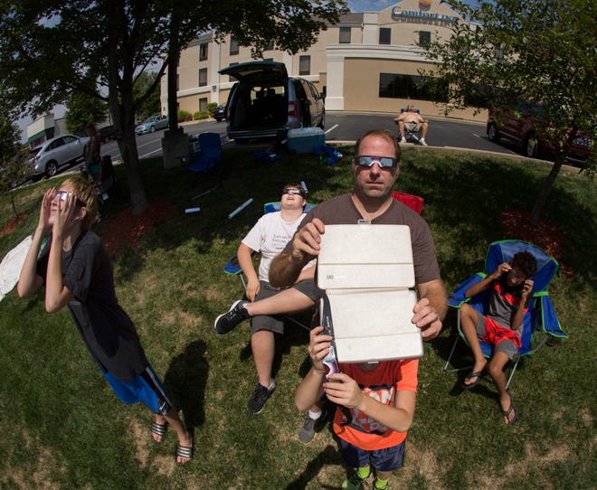 Chris Riegert and his 10-year-old son Morrie of Fond du Lac take a photo of the sun during total eclipse on August 21, 2017, in Pacific, Mo. The totality of the eclipse lasted about 2 minutes and 24 seconds in the city about 32 miles southwest of St. Louis.