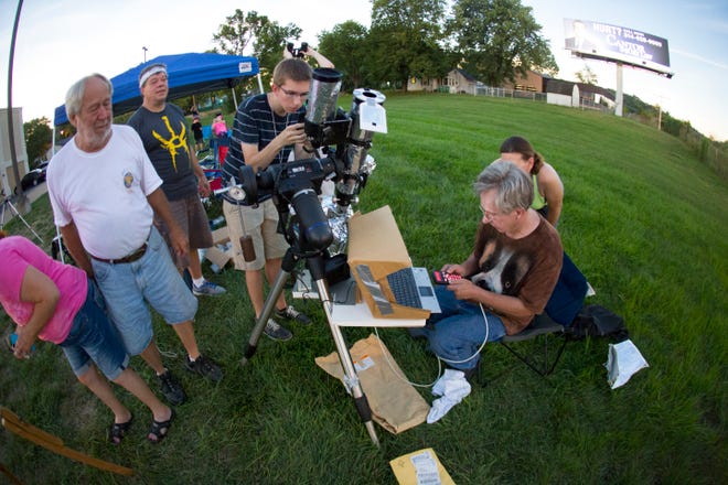 Astronomical artist and five-time eclipse veteran James Hervat (seated, brown shirt) records images of the sun during the solar eclipse totality Monday, Aug. 21, 2017, in Pacific, Mo. The totality of the eclipse lasted about 2 minutes and 24 seconds in the city about 32 miles southwest of St. Louis. The Kenosha resident was there with members of his extended family.