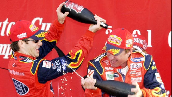Gordon, left, and a crew member spray each other  with champagne in victory lane after Gordon won his fourth career Winston Cup Series championship on Nov. 18, 2001. Gordon won six races and had 18 top-5 finishes.