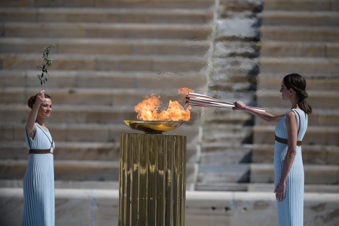 Greek actress Xanthi Georgiou dressed as an ancient Greek high priestess lights the olympic torch during the olympic flame handover ceremony for the 2020 Tokyo Summer Olympics in Athens. The ceremony is held behind closed doors as a preventive measure against the spread of the COVID-19 caused by the novel Coronavirus.