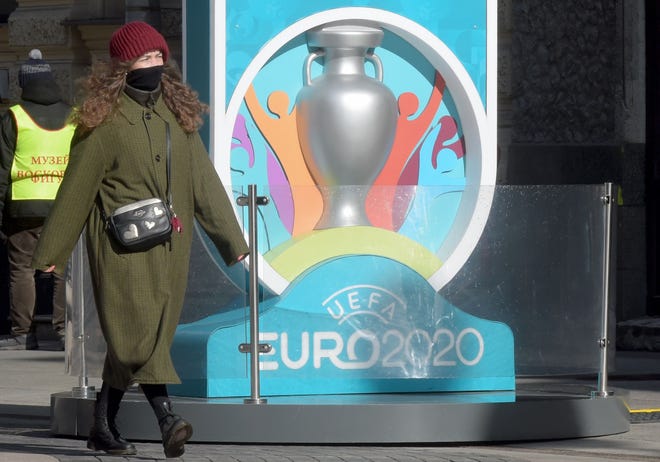 A woman wearing her scarf wrapped around her face walks past the Euro 2020 countdown clock - displaying 449 days left before the event - in downtown Saint Petersburg, Russia. The European Championship, due to be played in June and July this year, has been postponed until 2021 because of the coronavirus pandemic, European football's governing body UEFA said on March 17, 2020. UEFA announced that the new proposed dates for the tournament were June 11 to July 11 next year, as Euro 2020 becomes Euro 2021.