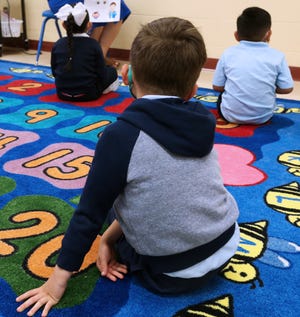 Students listens as their teacher Tita Torres goes over classroom rules in their prekindergarten-4 class  on the first day of school at Rogers Street Academy.
